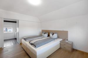- une chambre blanche avec un lit et une table de chevet dans l'établissement Haus 33, à Wittemberg