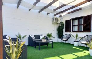 a patio with chairs and a table on green grass at Feliz Algarve in Albufeira