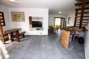 sala de estar con chimenea y TV en la pared en Sobrado Dos Colibris, en Ubatuba