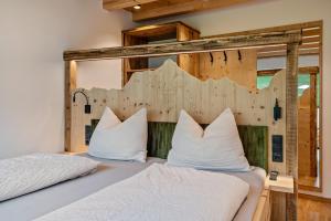 a bedroom with two beds with white pillows at Blosegghof Bergchalets Waldblick in Racines