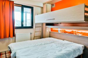 a bedroom with two beds and an orange wall at IMMODREAMS - L'Igloo - Avoriaz in Avoriaz