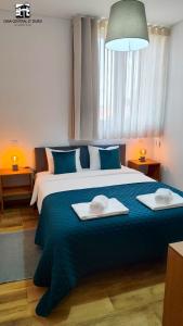una camera da letto con un grande letto con due asciugamani di Casa Central D'ouro a Tabuaço