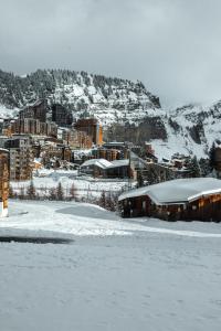 a snow covered city with buildings and a mountain at IMMODREAMS - Le Chalet - Avoriaz in Avoriaz