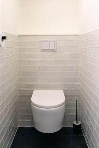 a white toilet in a white tiled bathroom at IMMODREAMS - Le Chalet - Avoriaz in Avoriaz +28 photos