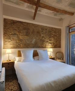 een slaapkamer met een groot wit bed met 2 lampen bij Casa Clotilde - Apartamento premium en Sant Joan de les Abadesses in Sant Joan de les Abadesses