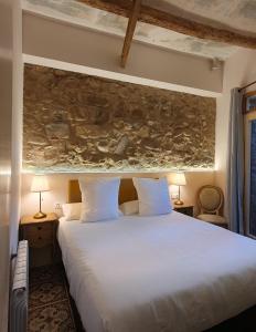 een slaapkamer met een groot wit bed met 2 lampen bij Casa Clotilde - Apartamento premium en Sant Joan de les Abadesses in Sant Joan de les Abadesses