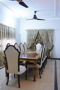 a dining room with a wooden table and chairs at Mohal's House in Lahore
