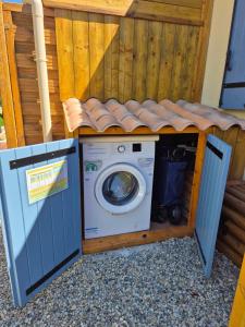 a washer and dryer under a wooden fence at Chez Florence et Bruno in Saint-Cyr-sur-Mer
