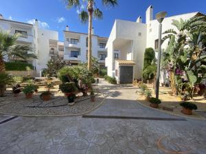 a building with palm trees and plants in a courtyard at Beautiful Apartment Alfaz del Sol in Alfaz del Pi