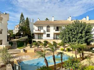 a villa with a swimming pool in front of a building at Beautiful Apartment Alfaz del Sol in Alfaz del Pi
