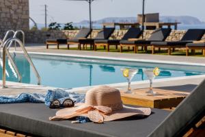 a hat and glasses next to a swimming pool at Basilico Suites Adults Only in Gouves