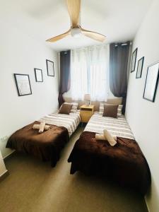 a bedroom with two beds and a ceiling fan at Apartment Sea Breeze I La Manga in La Manga del Mar Menor +40 photos