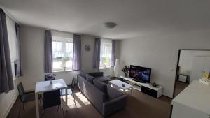 a living room with a couch and a tv at Penzion PANORAMA Janovičky in Broumov