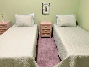 two beds sitting next to each other in a room at The Sanford Bandstand in Sanford