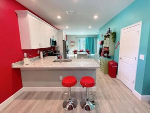 a kitchen with two red stools at a counter at The Sanford Bandstand in Sanford