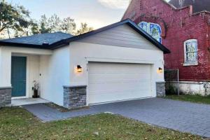 a red brick house with a white garage at The Sanford Bandstand in Sanford