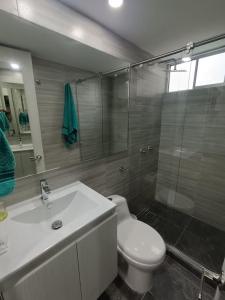 a bathroom with a toilet and a sink and a shower at Apartamento en el sur de Cali in Cali