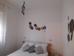 a bedroom with a bed and some clocks on the wall at Tra Vento e Mare in Lendinuso