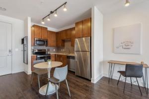 a kitchen with wooden cabinets and a table and chairs at Landing at Market Square Tower - 1 Bedroom in Downtown Houston in Houston