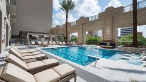 a swimming pool with lounge chairs and a building at Landing at Market Square Tower - 1 Bedroom in Downtown Houston in Houston