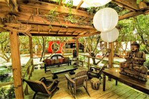 una terraza de madera con mesa, sillas y techo de madera. en Exotic Sukiya Tiny House Japanese Balinese Gardens en Homestead