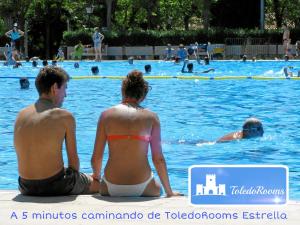 a man and a woman sitting in a swimming pool at Double Room in ToledoRooms VistaPark in Toledo