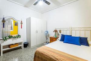 a bedroom with a large bed with blue pillows at Precioso apartamento con terraza en Valencia in Valencia