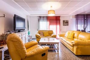 sala de estar con muebles de color amarillo y TV de pantalla plana. en Precioso apartamento con terraza en Valencia en Valencia