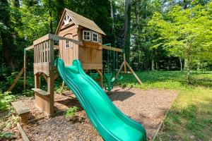 a playground with a slide and a house at The Milliken Getaway AC Beach Fire Pit BBQ in Traverse City