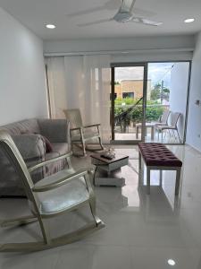 ein Wohnzimmer mit einem Sofa, Stühlen und einem Tisch in der Unterkunft Lujoso apartamento central in Montería