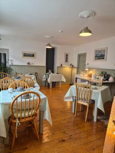 uma sala de jantar com mesas e cadeiras e uma cozinha em The Old Exchange em Clifden