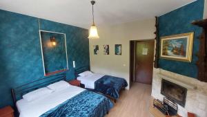 ein Hotelzimmer mit 2 Betten und einem Kamin in der Unterkunft Ziakas Rooms in Zákas