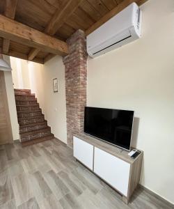 sala de estar con TV de pantalla plana y escalera en Casa Rural Casa Isabel, en Hervás