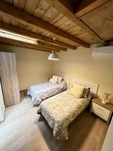 1 dormitorio con 2 camas y mesa con lámpara en Casa Rural Casa Isabel, en Hervás