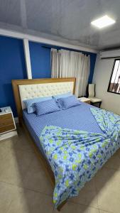 1 dormitorio con 1 cama con pared azul en Hospedaje Balcones de la Colina, en Floridablanca