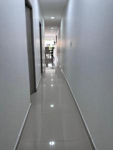 um corredor com pisos brancos e uma sala de jantar em Lujoso apartamento central em Montería