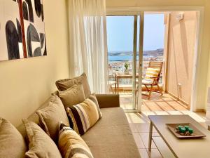 ein Wohnzimmer mit einem Sofa und einem Tisch in der Unterkunft Amazing Ocean View Apartment in Poris de Abona