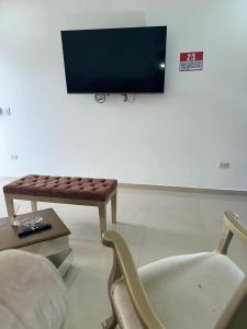 sala de estar con banco y TV en Lujoso apartamento central, en Montería
