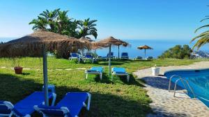 - un groupe de chaises longues et de parasols sur une plage dans l'établissement Cortijo de la luna la casita, à Taramay