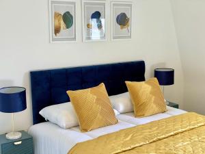 two beds with yellow and white pillows in a bedroom at Minster Peek With Free Parking in York