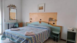 a bedroom with a bed with two towels on it at Hotel Rosy in Bellaria-Igea Marina