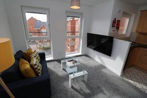 a living room with a couch and a tv at 2 Bedroom Penthouse in Coventry - Private Parking in Coventry