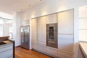 a kitchen with stainless steel refrigerator and white walls at das zellersee in Zell am See