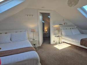 um quarto branco com 2 camas e uma janela em The Old Exchange em Clifden