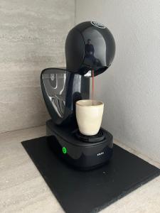 une cafetière avec une tasse sur un fond noir dans l'établissement Groenendijk 8, à Oostduinkerke