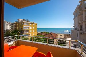 a balcony with an orange table and chairs and the beach at Hotel Vila Misiri in Durrës