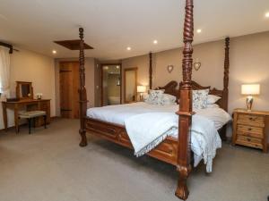 una camera con letto a baldacchino e lenzuola bianche di The Croft a Holsworthy