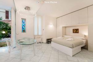 sypialnia z łóżkiem i szklanym stołem w obiekcie Élite, Terre Marine w mieście La Spezia