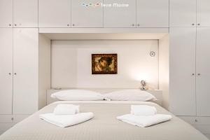 biała sypialnia z dużym łóżkiem z 2 białymi poduszkami w obiekcie Élite, Terre Marine w mieście La Spezia