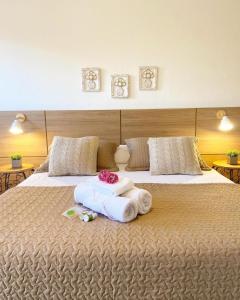 a large bed with towels and flowers on it at Pousada Luz do Sol in Carrancas